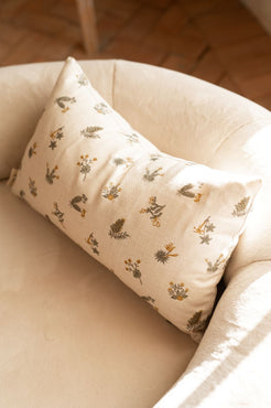 cojín de flores mostaza sobre lino beige