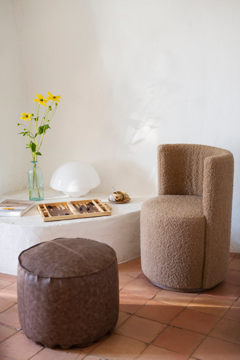 Rincón de hogar con sillón y puf en color marrón