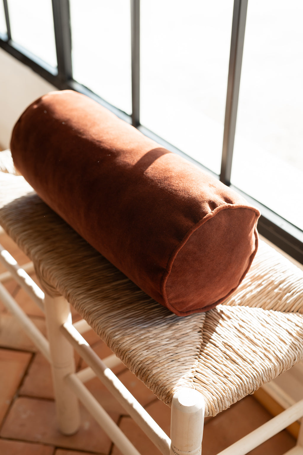 Cojín cilindrico en terciopelo granate