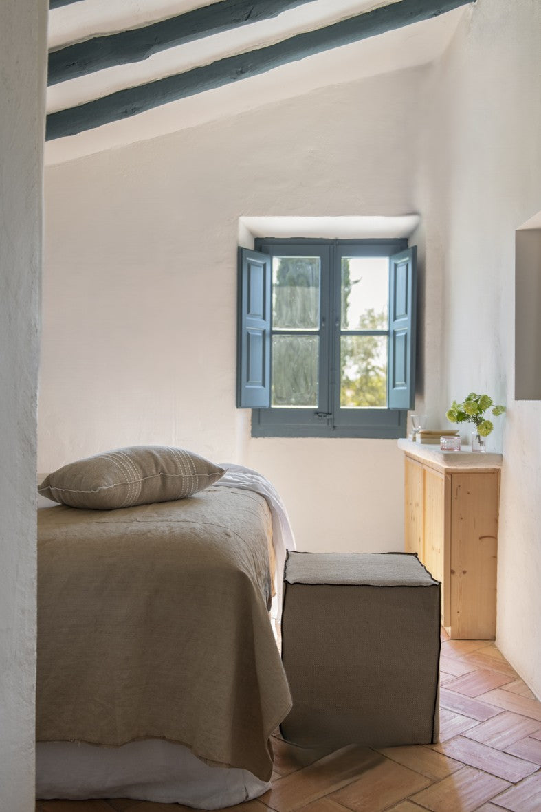 Puf desenfundable con tejido de lino y yute y detalle de hilatura negra en las costuras